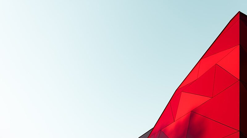 Bild vom Himmel mit einer roten Glasfront unten in der Ecke