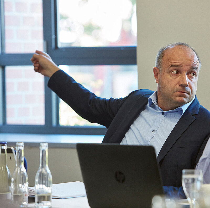 Mann sitzt in einem Meeting