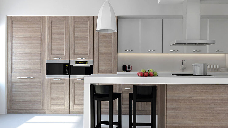 Helle, moderne Küche mit Holzfronten, weißer Kochinsel, zwei Hockern und Pendelleuchte